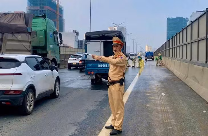 Lực lượng chức năng nhanh chóng xử lý bùn đất trên vành đai 3, phân luồng giao thông để đảm bảo an toàn cho các phương tiện. Ảnh: Công an cung cấp