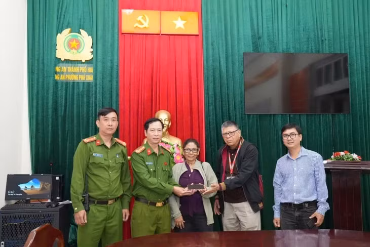 Công an phường Phú Xuân (TP Huế) trả điện thoại cho du khách người Mỹ bị cướp giật khi đang tham quan kinh thành Huế - Ảnh: Công an phường Phú Xuân