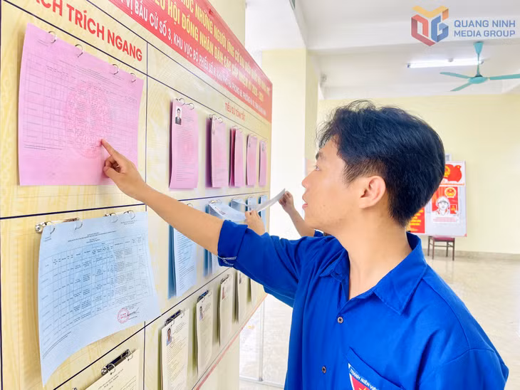Em Bùi Xuân Cảnh (lớp 12, Trường THPT Vũ Văn Hiếu, phường Hà Tu) tìm hiểu các quy định về ngày bầu cử tại khu vực bỏ phiếu.