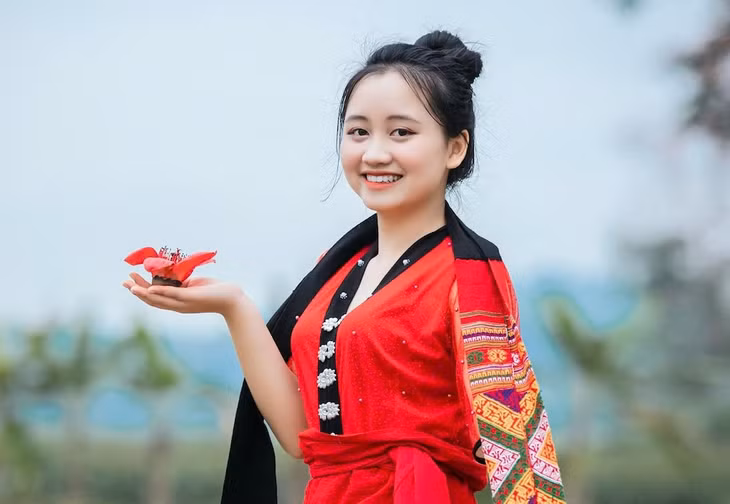 Du khách thích thú check-in dưới những tán hoa đỏ rực, lưu lại khoảnh khắc đẹp giữa không gian làng quê yên bình. Ảnh: Rạng Đông