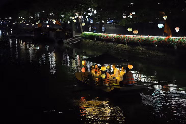 Vào buổi tối, khu phố rực sáng với đèn lồng, du khách có thể trải nghiệm ngồi thuyền ngắm cảnh, thả hoa đăng.