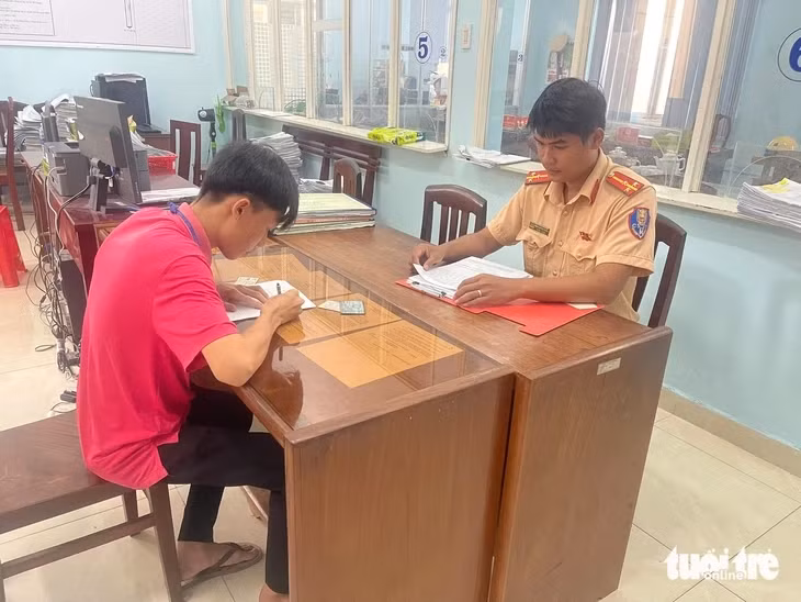 Lực lượng CSGT lập biên bản xử lý vi phạm với T. - Ảnh: HOÀI THƯƠNG