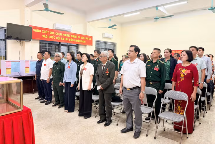 Các đại biểu tham dự lễ chào cờ tại điểm bầu cử nhà văn hoá khu Đồn Điền, phường Tuần Châu.