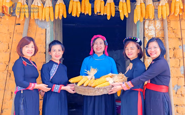 Du khách thích thú diện trang phục, check-in trước căn nhà đất của người Tày.
