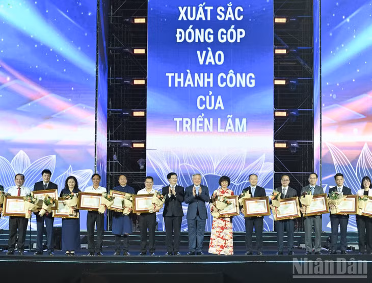 Phó Thủ tướng Thường trực Nguyễn Hòa Bình và Phó Thủ tướng Mai Văn Chính trao Bằng khen của Thủ tướng Chính phủ tặng các đơn vị, trong đó có Báo Nhân Dân, đã có thành tích xuất sắc trong công tác tổ chức và tham gia triển lãm. (Ảnh: TRẦN HẢI)