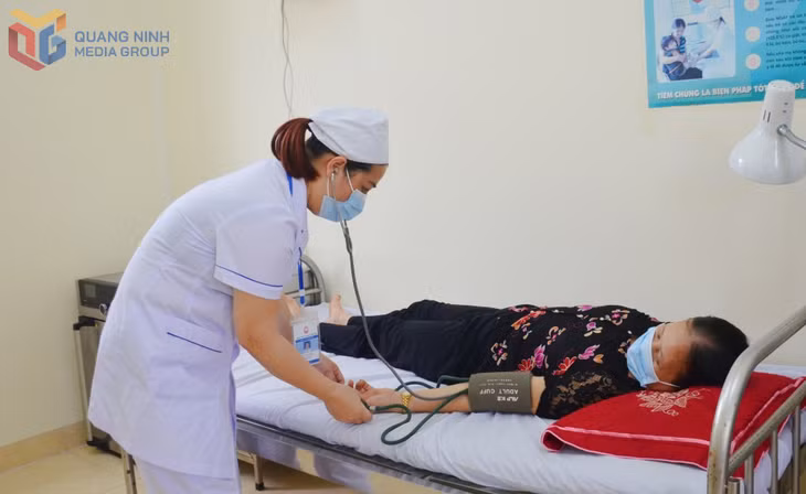 Nhân viên Trạm Y tế Hiệp Hòa đo huyết áp cho người dân đến khám bệnh. Ảnh: Nguyễn Hoa