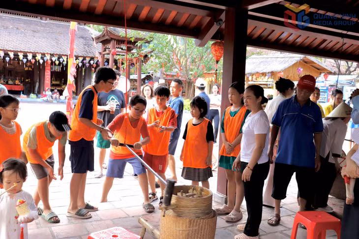 Các em nhỏ thích thú với trải nghiệm xay thóc, giã gạo. 