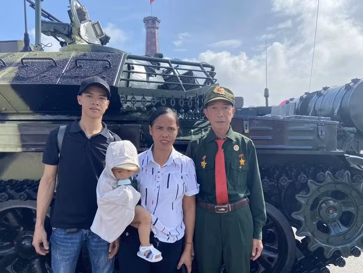 Ông Đậu Đình Thanh (bìa phải) cùng vợ và con trai, cháu trai tham quan Triển lãm thành tựu đất nước - Ảnh: T.ĐIỂU