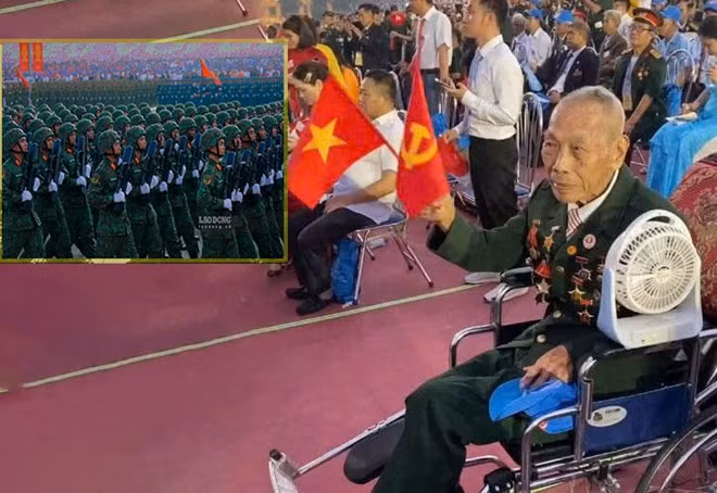 Ông Lê Bình vẫy cờ Đảng, cờ Tổ quốc khi đoàn diễu binh đi qua lễ đài. Ảnh: Lê Thường - Tuấn Anh