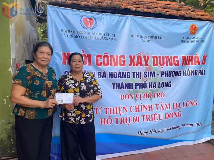 Bà Lê Thị Minh Huệ (trái) đại diện Chi hội Phụ nữ khu 5 Hồng Hải trao kinh phí hỗ trợ xây dựng nhà ở cho gia đình có hoàn cảnh khó khăn.