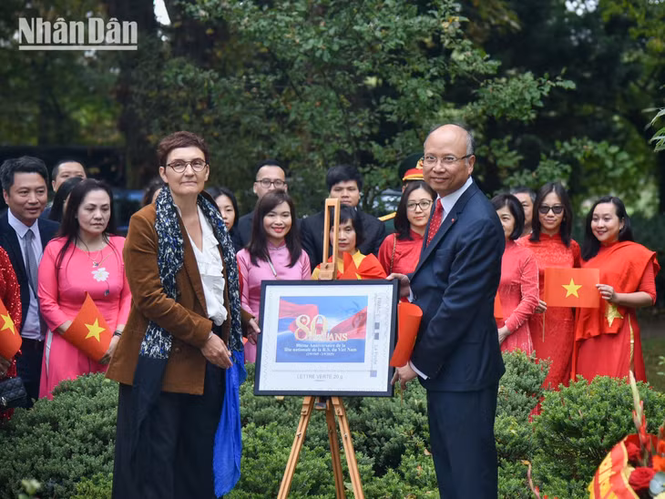 Đại sứ Đinh Toàn Thắng trao mẫu tem bưu chính đặc biệt kỷ niệm 80 năm Quốc khánh Việt Nam tặng bà Sabine Pesier. (Ảnh: MINH DUY)