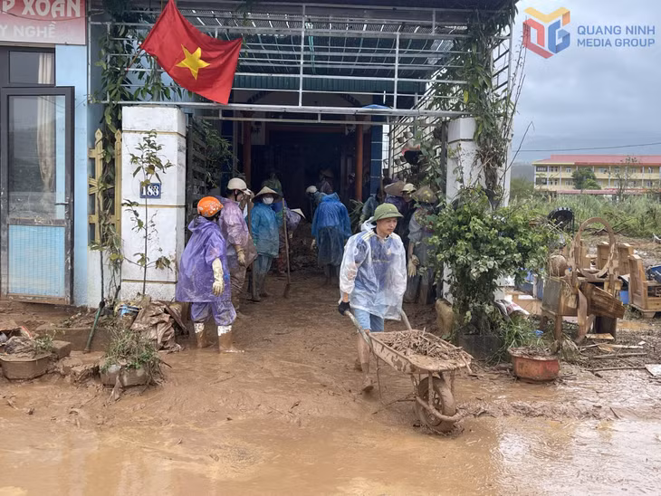 Người dân thôn Đá Trắng (xã Thống Nhất) và các lực lượng địa phương tham gia dọn bùn đất sau mưa lũ. Ảnh: Minh Đức