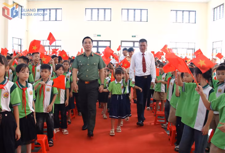 Thiếu tướng Trần Văn Phúc và Hiệu trưởng Nhà trường đưa học sinh lớp 1 vào dự lễ khai giảng.
