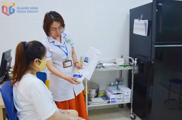Nhân viên y tế của CDC Quảng Ninh giới thiệu vắc-xin trước khi tiêm cho người dân đến tiêm dịch vụ tại đơn vị.