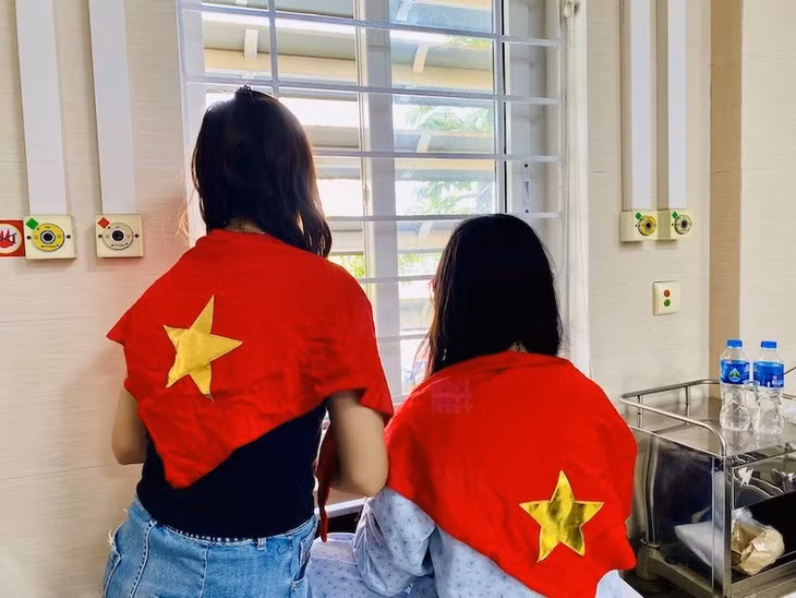 Bệnh nhân và người nhà theo dõi “concert” quốc gia A80 qua cửa sổ bệnh viện Xanh Pôn. Ảnh: Thùy Linh