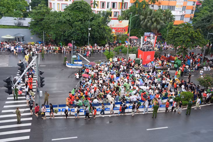 17h, mưa đã tạnh, lượng người đổ về khu vực Kim Mã mỗi lúc một đông. Nhiều gia đình, nhóm bạn mang theo ghế xếp, căng bạt giữ chỗ, chuẩn bị theo dõi diễu binh, diễu hành sáng mai 2.9. Ảnh: Xuân Hiệp - Huyền Trang