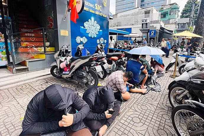 Nhiều bạn trẻ ngồi bệt trên vỉa hè để đợi mua vàng SJC ở chi nhánh tại phường Bàn Cờ (TP.HCM)
