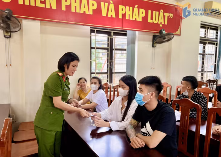 Cán bộ quản giáo phát thẻ sim điện thoại cho người được đặc xá.
