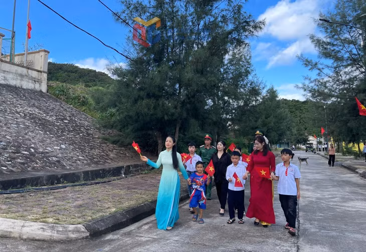 Các cô giáo và các chú bộ đội ân cần chăm chút, dắt tay các em học sinh Đảo Trần đến trường dự lễ khai giảng.
