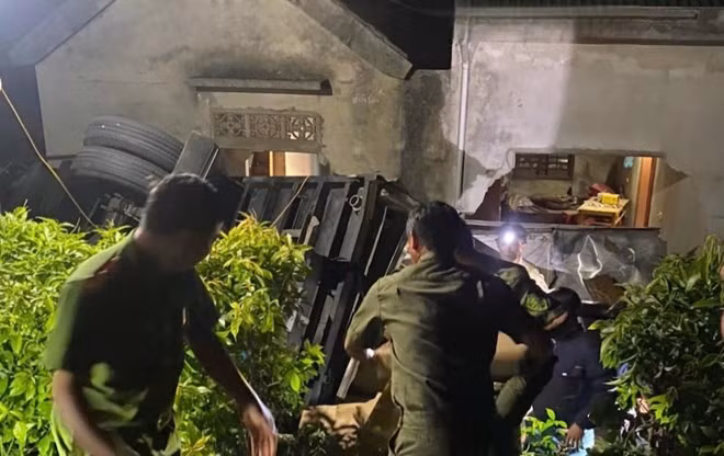 Xe tải mất lái tông vào nhà dân khiến xe bị lật ngửa, lực lượng Công an xã Vĩnh Hoàng và người dân phải bốc dỡ hàng đông lạnh trên xe sang phương tiện khác. Ảnh: Công an xã Vĩnh Hoàng