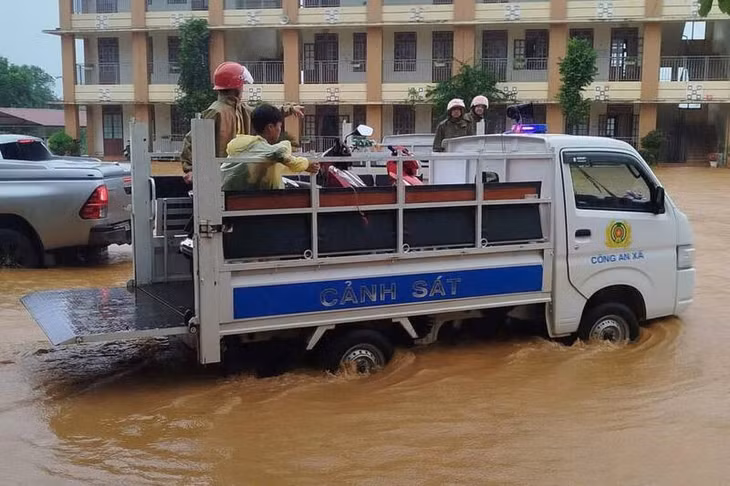 Lực lượng chức năng xã Vân Hồ hỗ trợ học sinh và giáo viên di chuyển đến nơi an toàn. Ảnh: Trường Sơn