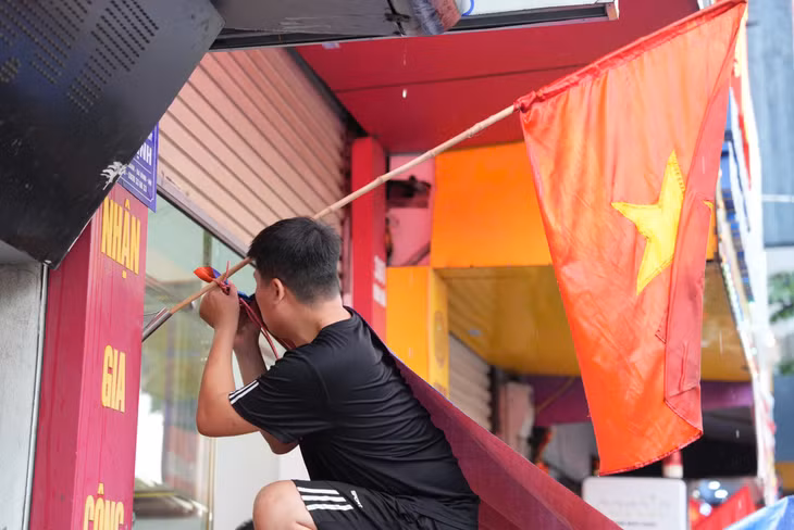 Người dân tại khu vực Kim Mã căng bạt che mưa, chuẩn bị vị trí từ sớm để ngày mai theo dõi buổi diễu binh, diễu hành mừng Quốc khánh 2.9. Ảnh: Xuân Hiệp - Huyền Trang
