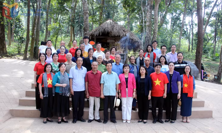 Các đại biểu chụp ảnh lưu niệm tại Lán Nà Nưa, xã Tân Trào, tỉnh Tuyên Quang.