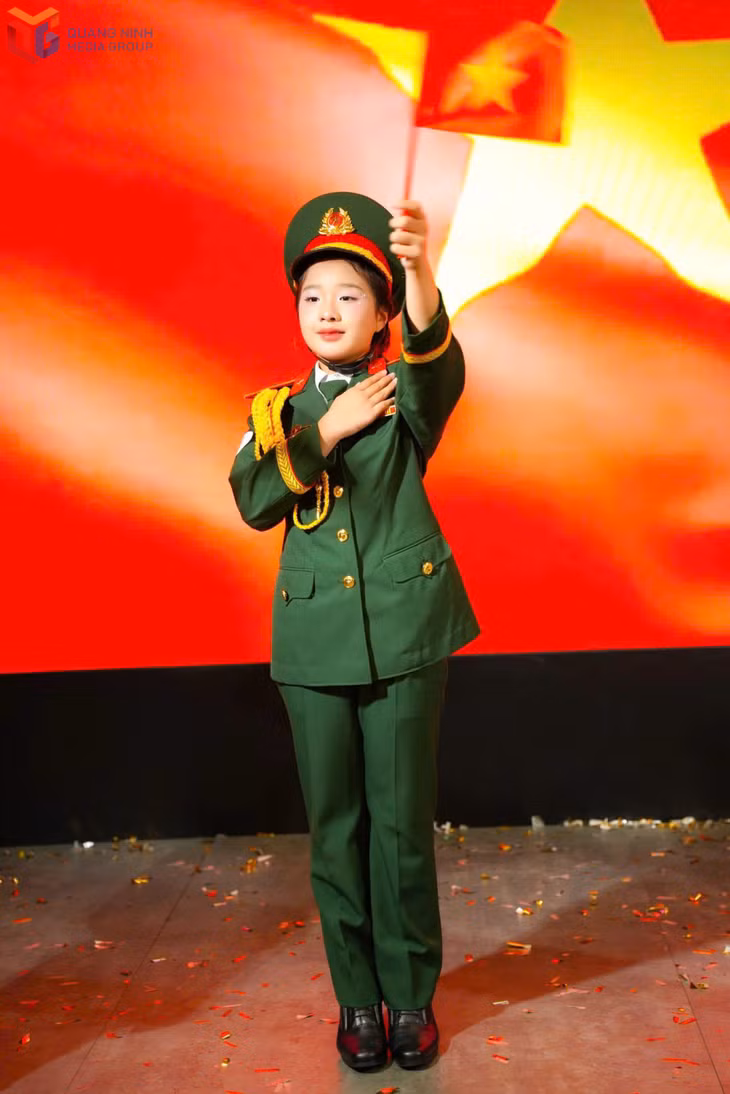 Bảo Nghi trình diễn trong bộ quân phục màu xanh.