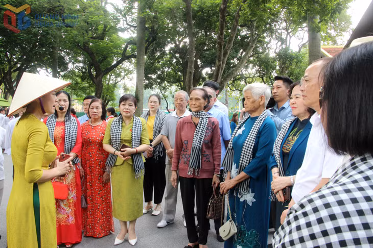 Các đại biểu được hướng dẫn viên giới thiệu về Khu di tích Chủ tịch Hồ Chí Minh.