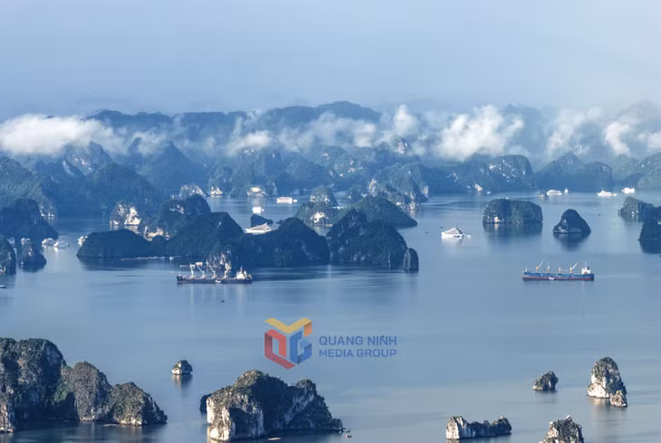 Núi đá và mây trời hòa quyện như những nốt nhạc nhẹ nhàng lướt trên mặt vịnh yên ả. 