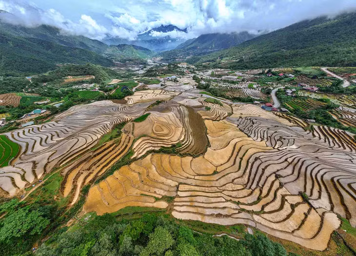 Trong ánh nắng đầu ngày, hình ảnh ruộng bậc thang ngập nước phản chiếu hình ảnh người dân làm việc gây ấn tượng với du khách. Ảnh: NAG Cao Như Thụy