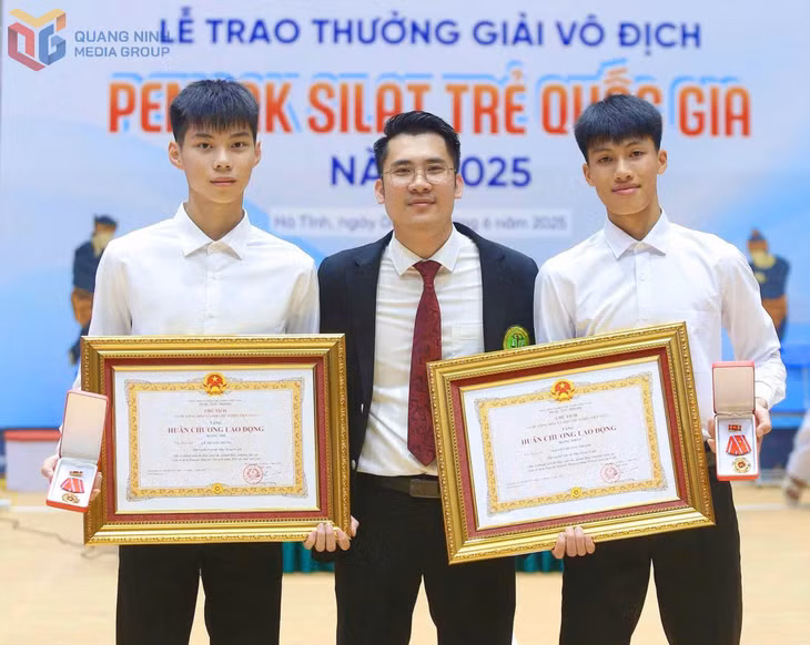 VĐV Nguyễn Quang Thành (phải), Lê Thành Trung (trái) chia vui cùng HLV Nguyễn Thái Linh khi vinh dự nhận Huân chương Lao động của Chủ tịch nước.