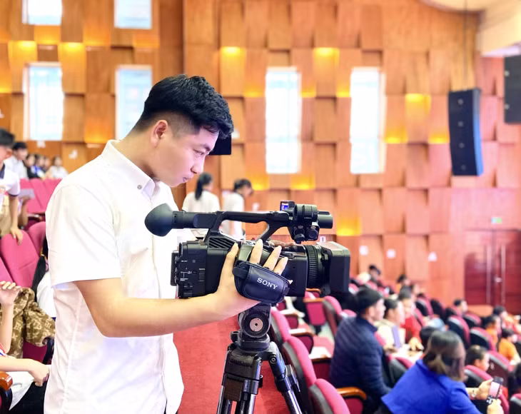 Phóng viên Trần Hoàn tác nghiệp tại chương trình văn nghệ tổ chức tại hội trường Trung tâm Văn hoá huyện.