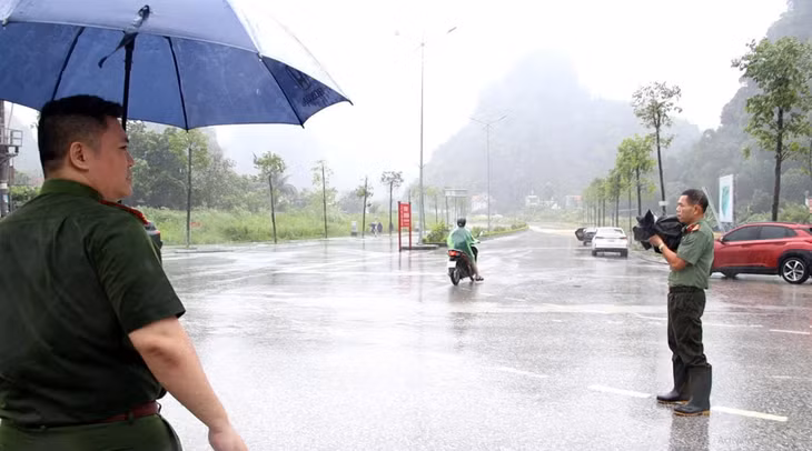 Phóng viên Nguyễn Khánh tác nghiệp dưới trời mưa bão.