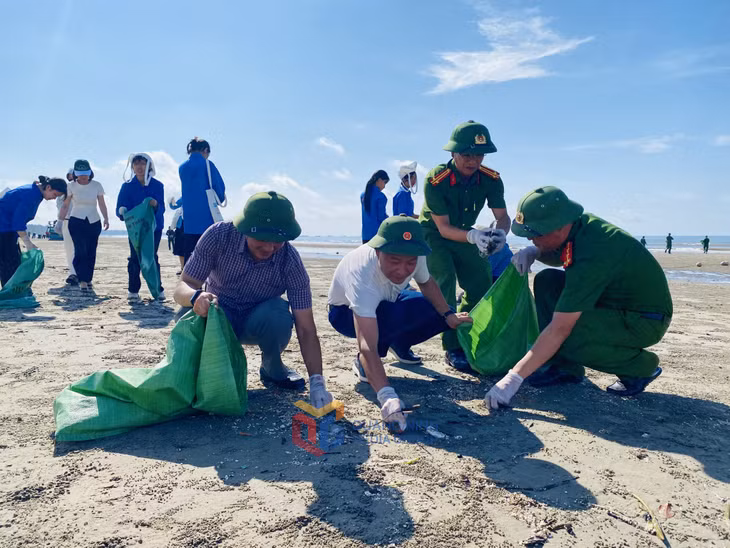 Các đại biểu, nhân dân tham gia dọn vệ sinh môi trường biển phía trước trụ sở Ban quản lý khu du lịch Trà Cổ đến Ngã Ba Ông Thái.