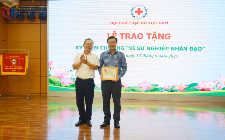 Đồng chí Vũ Hồng Hải, Chủ tịch Hội Chữ thập đỏ tỉnh Quảng Ninh trao tặng Kỷ niệm chương "Vì sự nghiệp nhân đạo" cho đồng chí Nguyễn Thế Lãm, Giám đốc Trung tâm Truyền thông tỉnh.