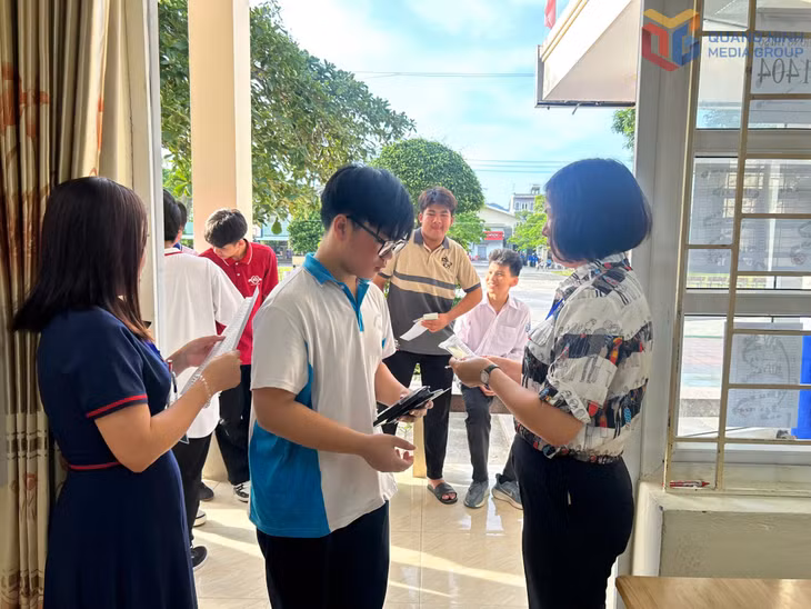 Cán bộ coi thi tại điểm thi Trường THPT Hải Đảo (huyện Vân Đồn) làm thủ tục gọi thí sinh vào phòng thi, kiểm tra thẻ dự thi của thí sinh. Ảnh: Trúc Linh.