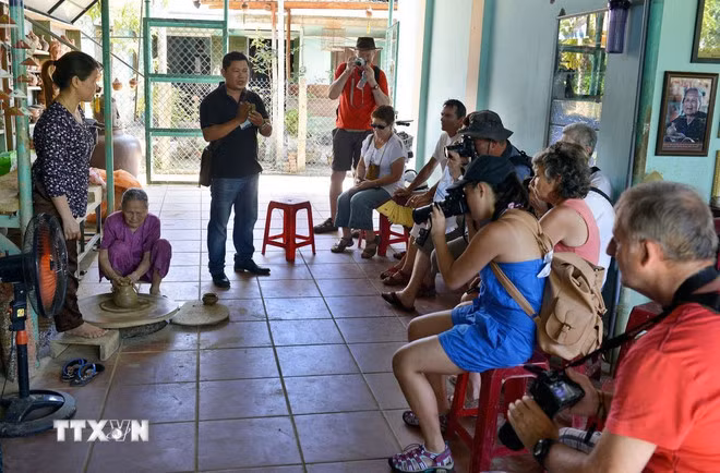 Khách du lịch thăm quan, xem và nghe giới thiệu về cách làm gốm truyền thống của người dân Thanh Hà. (Ảnh: Thanh Hà/TTXVN)