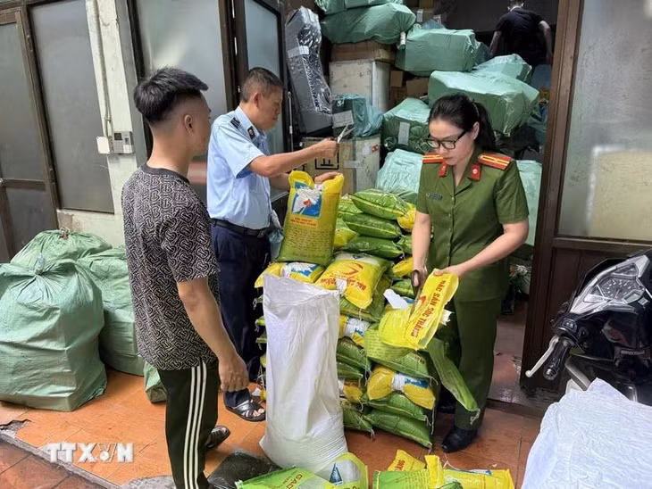 Lực lượng chức năng kiểm tra số gạo vi phạm. (Ảnh: TTXVN phát)