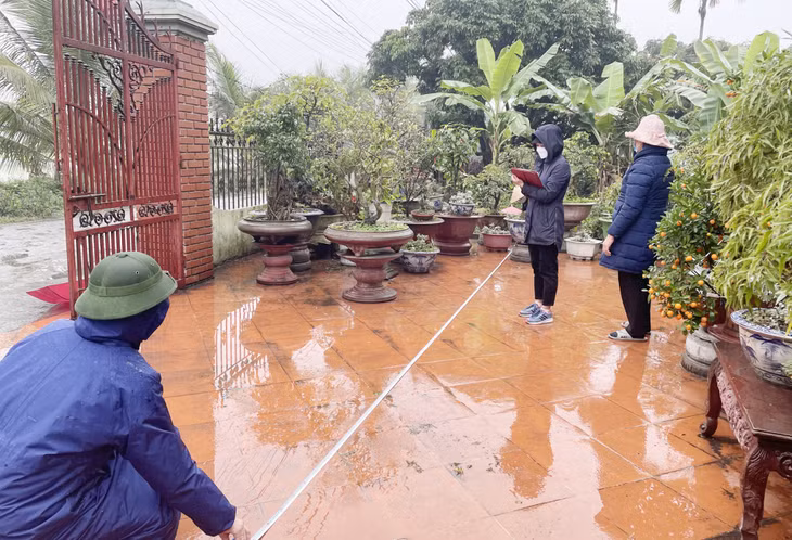 Cán bộ Trung tâm Phát triển quỹ đất TX Đông Triều đo đạc, lập phương án bồi thường GPMB phục vụ thi công tuyến đường ven sông.