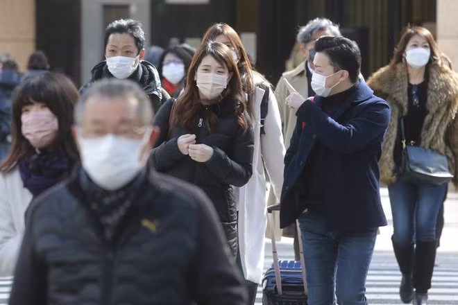 Những người đi bộ đeo khẩu trang trên một con phố ở Tokyo, Nhật Bản vào ngày 7/2. Ảnh: AP.