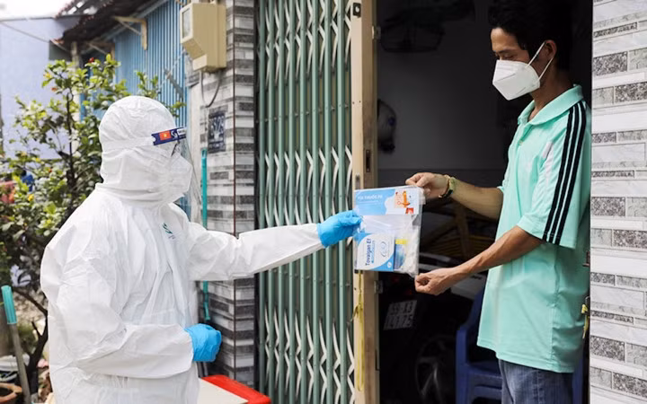 Nhân viên y tế cấp phát thuốc cho người mắc COVID-19 điều trị tại nhà. (Ảnh minh hoạ: SKĐS)