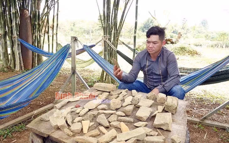 Nhà nông Triệu Dương với những vật dụng bằng đá được sưu tầm trong vườn điều sinh thái của mình