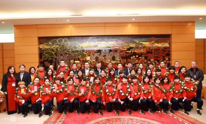 Đội tuyển nữ Việt Nam chụp ảnh lưu niệm cùng các lãnh đạo sau khi xuống sân bay Nội Bài.