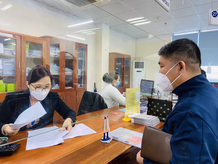 Cán bộ Trung tâm Hành chính công thành phố hướng dẫn người dân scan các thủ tục liên quan đến lĩnh vực đất đai lên Cổng dịch vụ công.