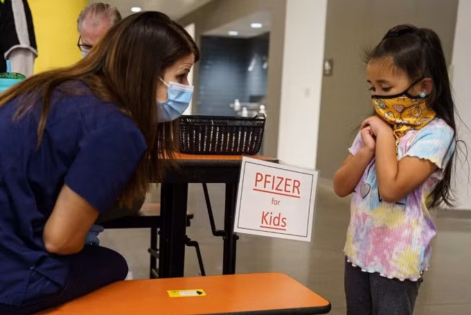 Một em nhỏ 5 tuổi được y tá hướng dẫn trước khi tiêm vaccine Pfizer tại thành phố Albuquerque, Mỹ. Ảnh: NY Times