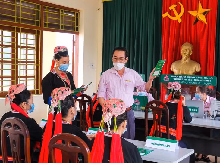 Cán bộ Ngân hàng CSXH Quảng Ninh hướng dẫn người dân TP Hạ Long theo dõi các khoản vay.