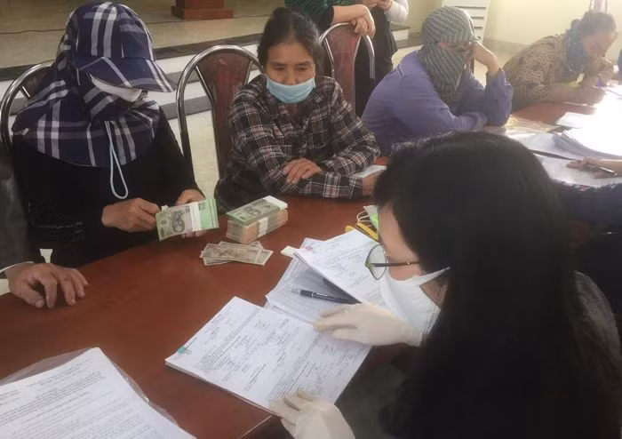 Người dân khu Xuân Quang, phường Yên Thọ (TX Đông Triều) nhận tiền đền bù, hỗ trợ GPMB và làm thủ tục bàn giao mặt bằng thực hiện dự án. Ảnh: Xuân Quảng (CTV)