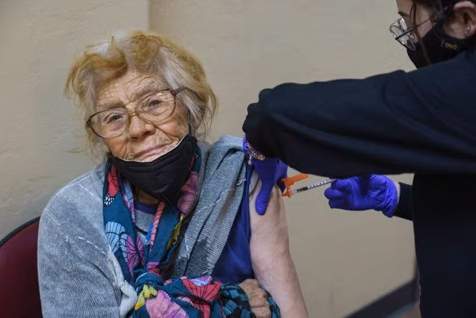 Một cụ bà 85 tuổi được tiêm vaccine Covid-19 ở Douglas, Mỹ, tháng 2/2022. Ảnh: NY Times