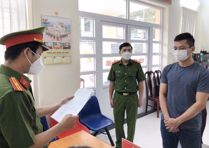 Cơ quan CSĐT Công an tỉnh Cà Mau tống đạt quyết định khởi tố bị can, bắt tạm giam Lê Sơn Lĩnh (bìa phải) về hành vi lừa đảo chiếm đoạt tài sản.